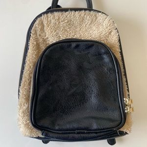 Black and fur backpack purse with gold zippers.